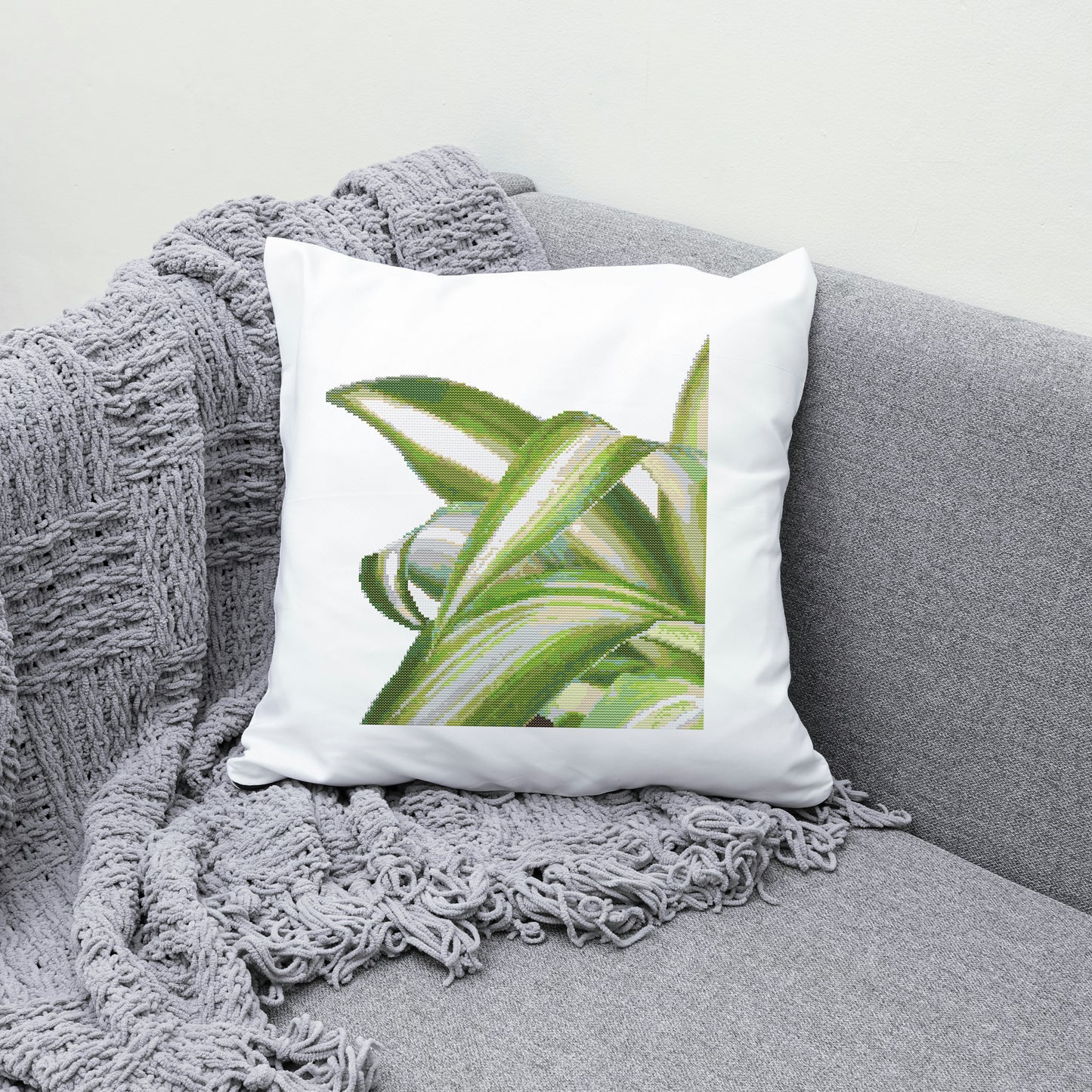 Decorative pillow with green leaf design on a gray couch