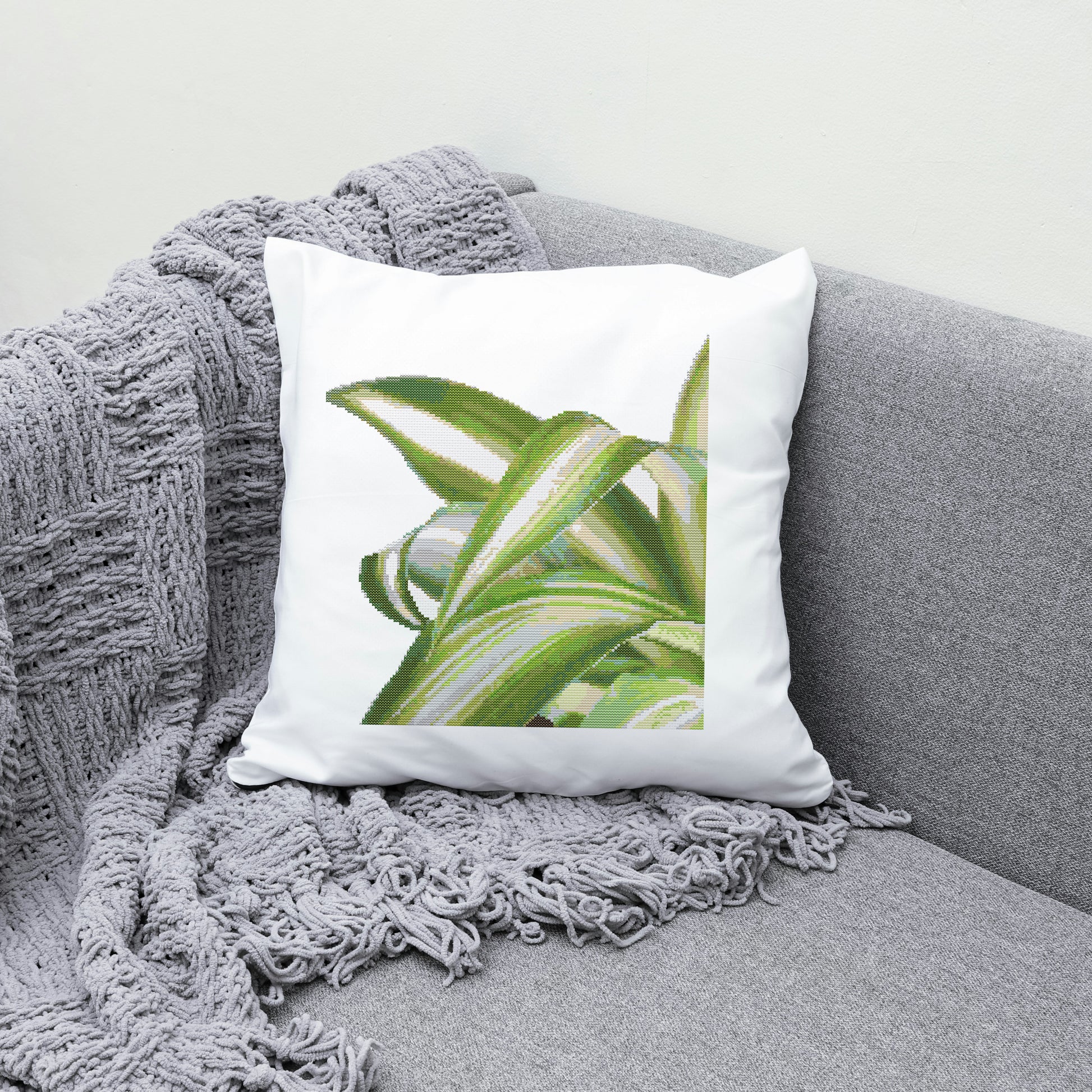 Decorative pillow with green leaf design on a gray couch
