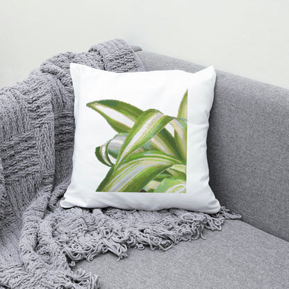 Decorative pillow with green leaf design on a gray couch