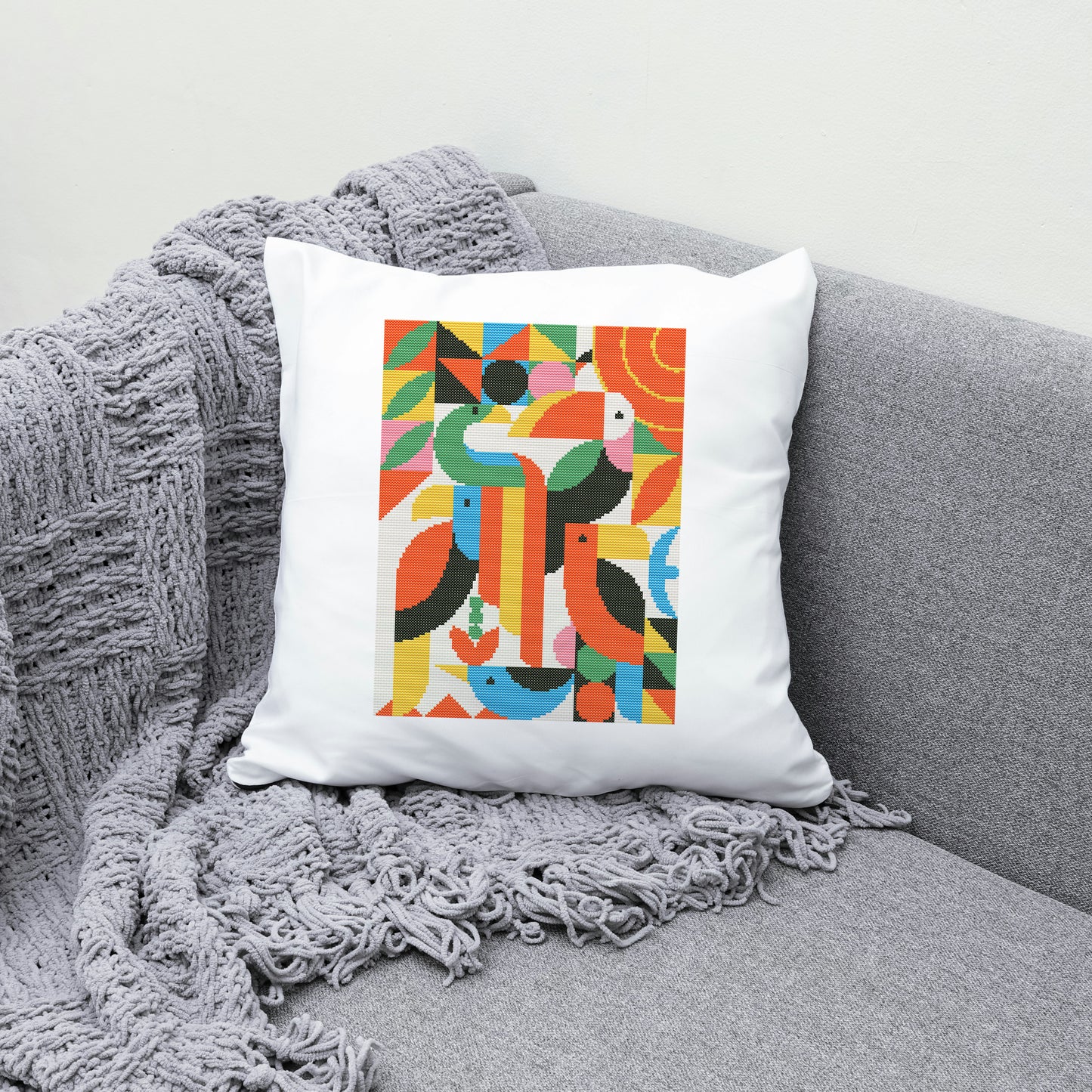 Decorative pillow with colorful geometric pattern on a gray couch