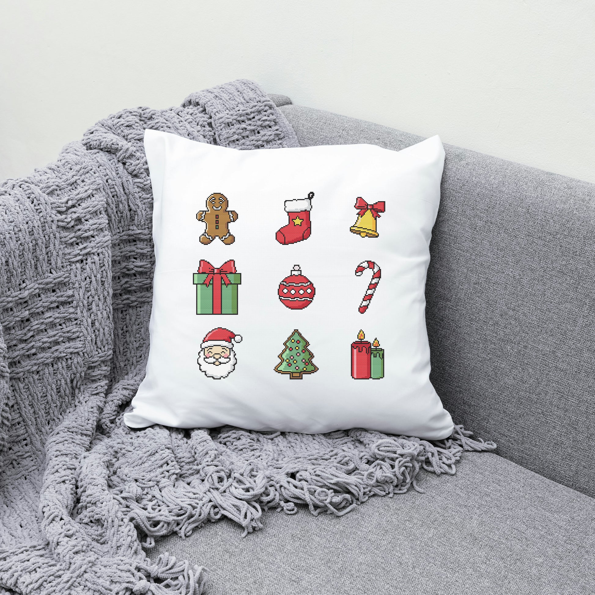 White pillow with Christmas-themed icons on a gray couch