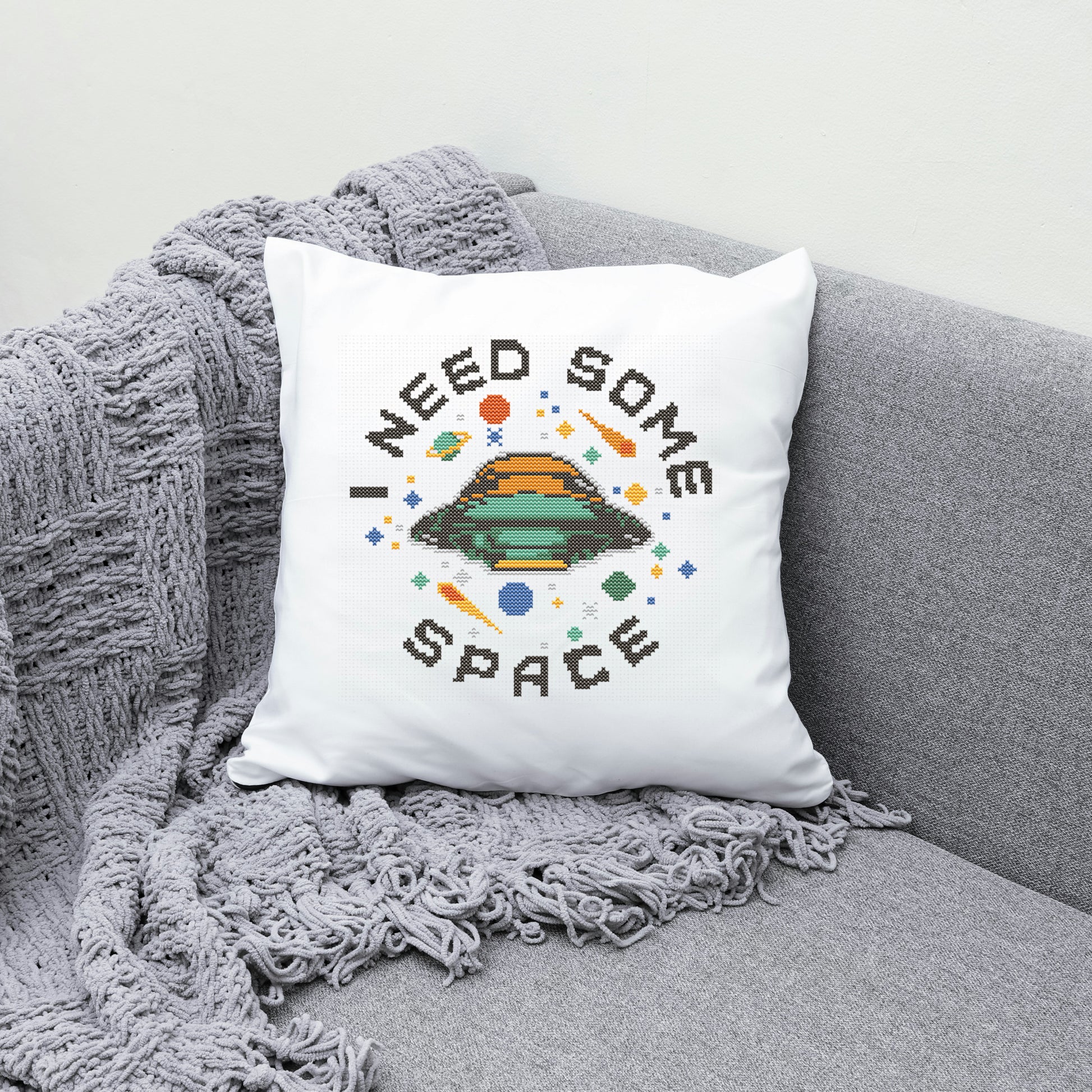 White pillow with 'I Need Some Space' design on a gray couch