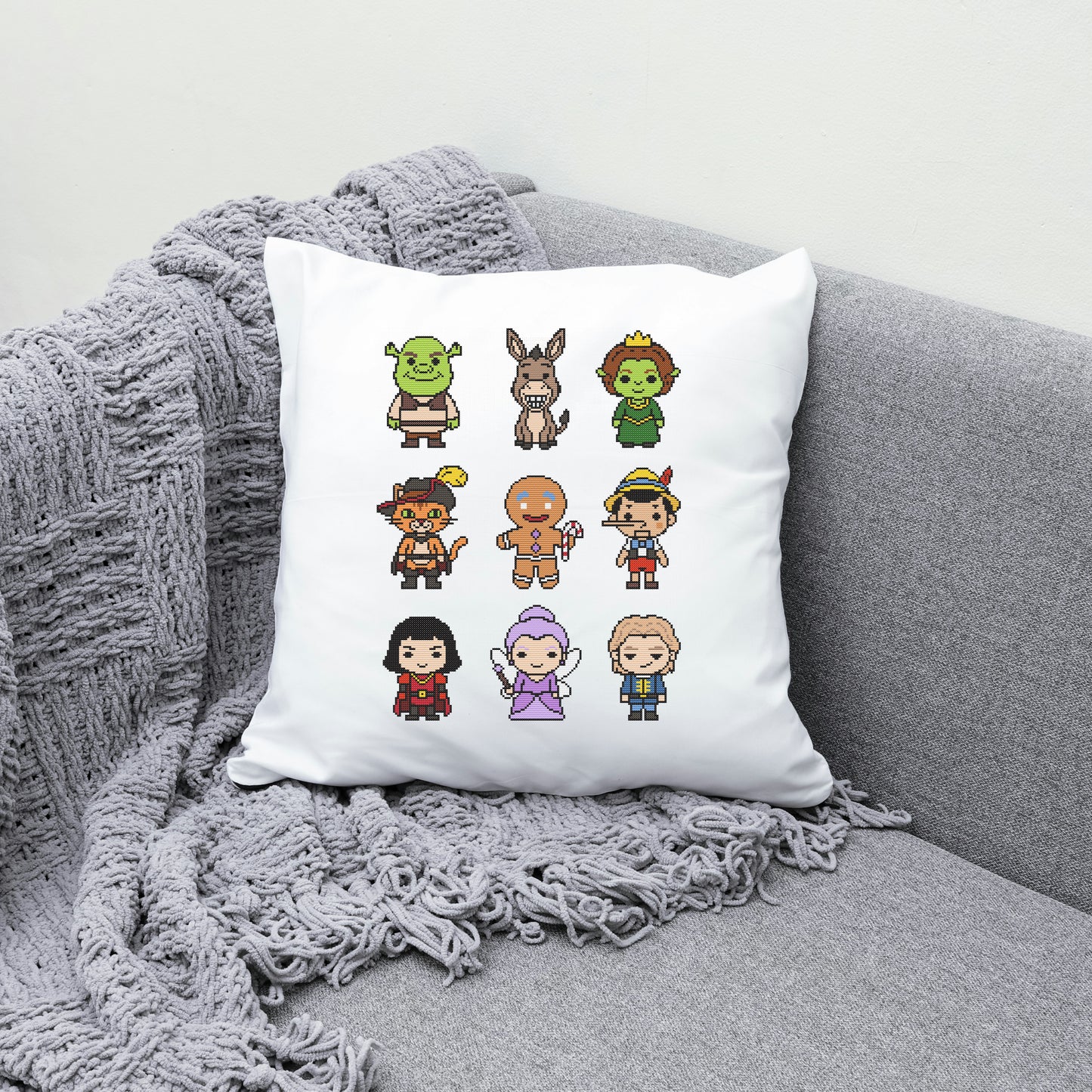 White pillow with cartoon character designs on a gray couch