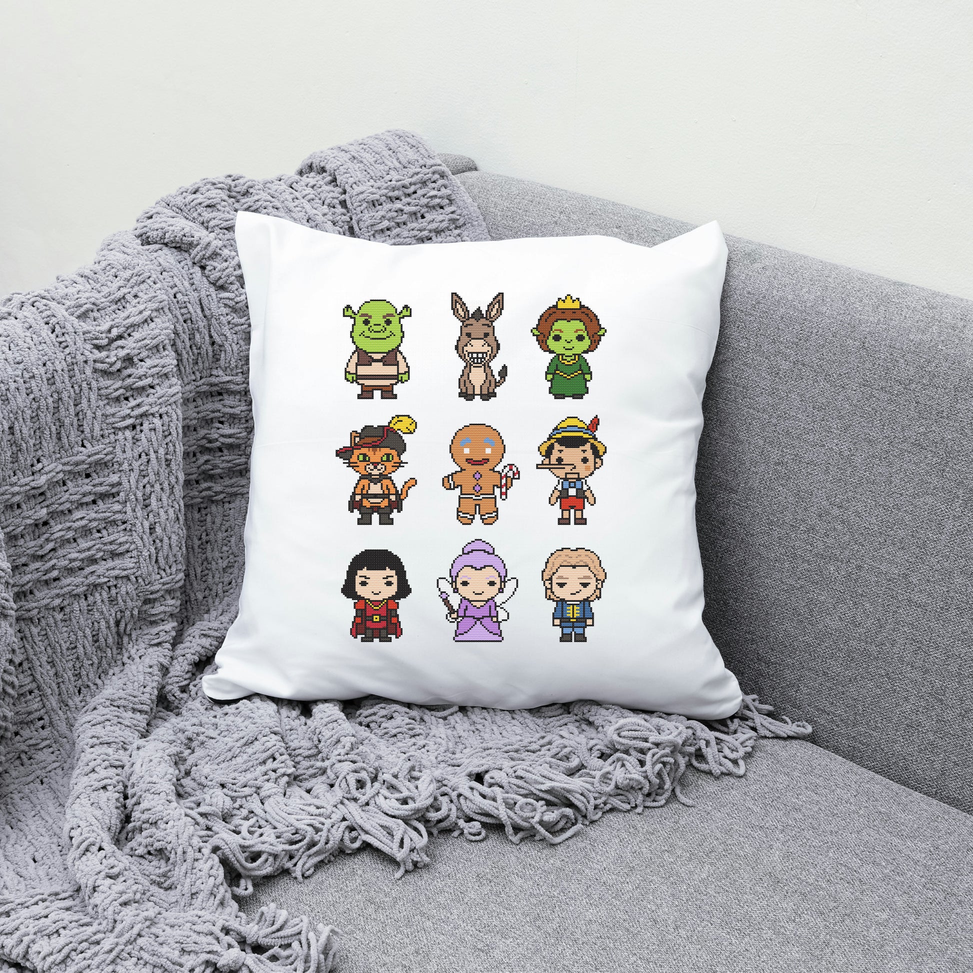 White pillow with cartoon character designs on a gray couch