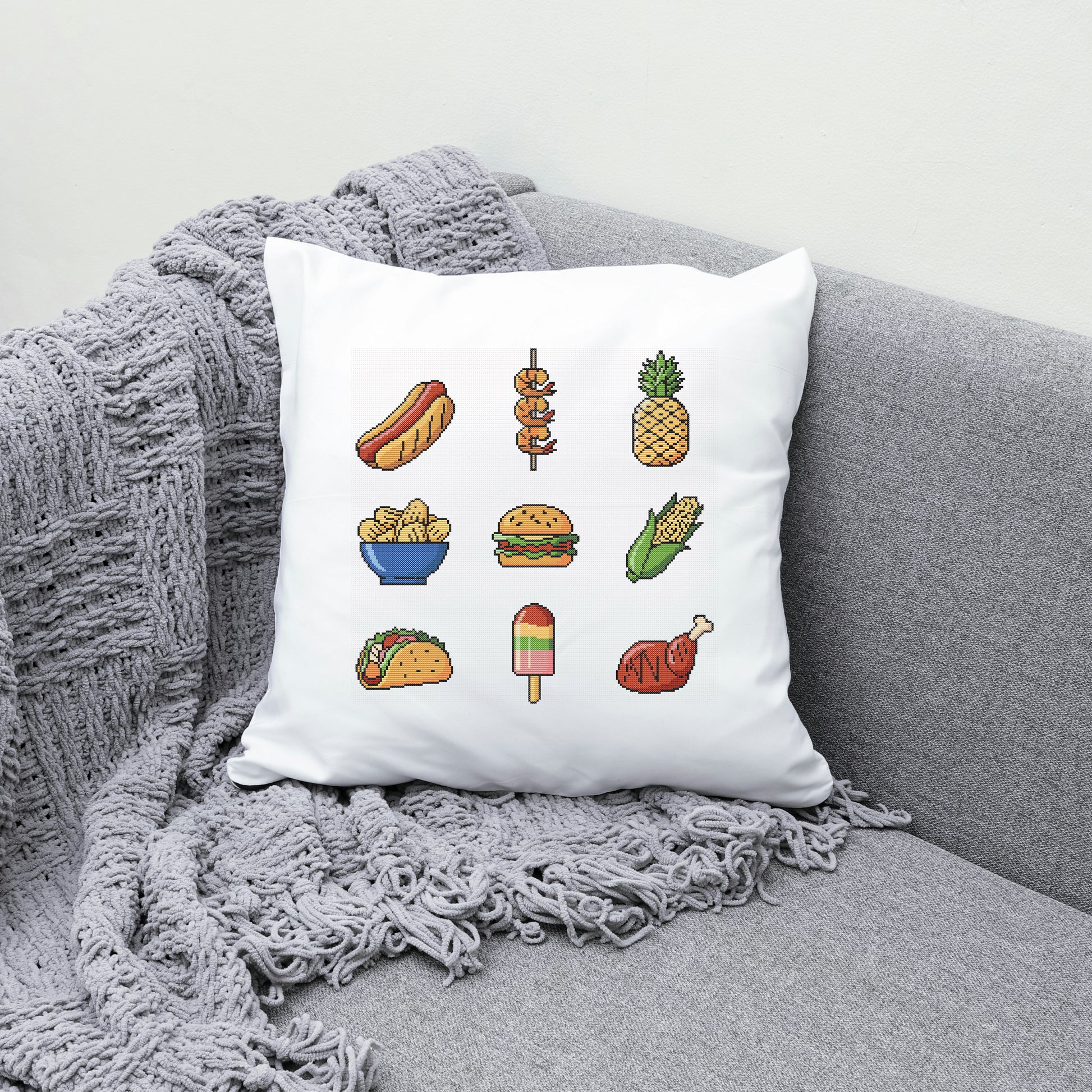 White pillow with food illustrations on a gray couch