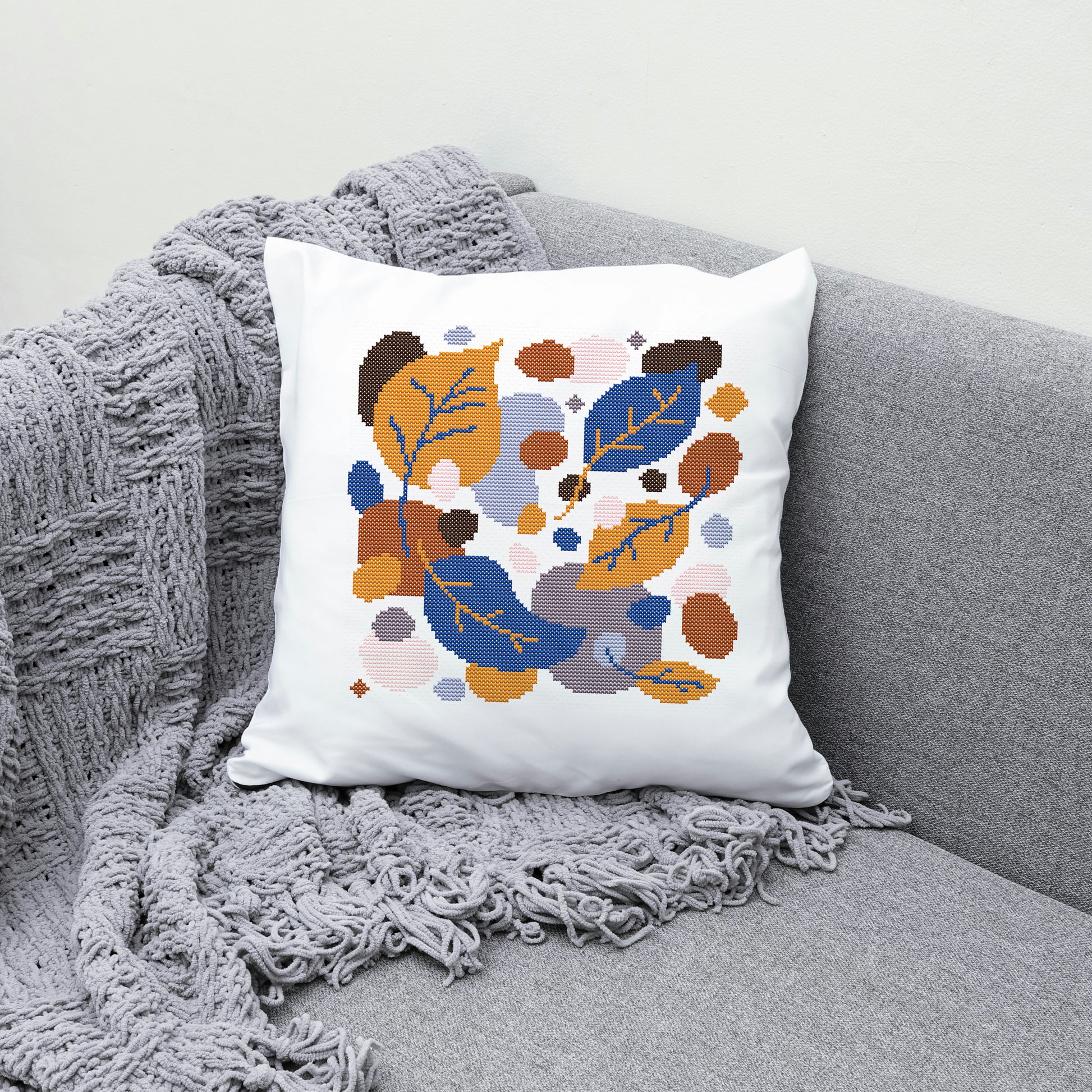 Decorative pillow with leaf pattern on a gray couch