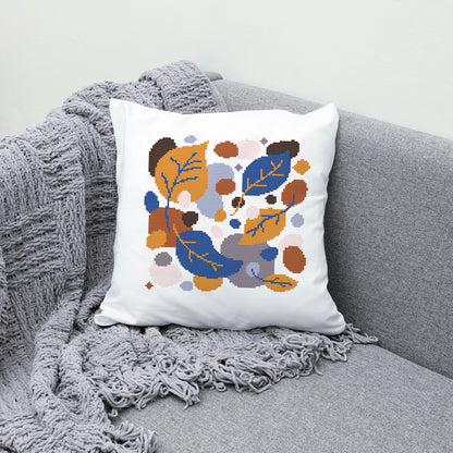 Decorative pillow with leaf pattern on a gray couch