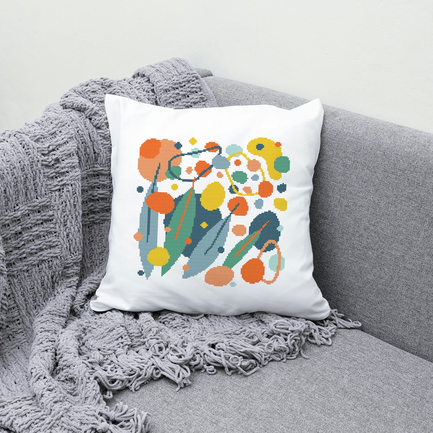 Decorative pillow with colorful abstract design on a gray couch