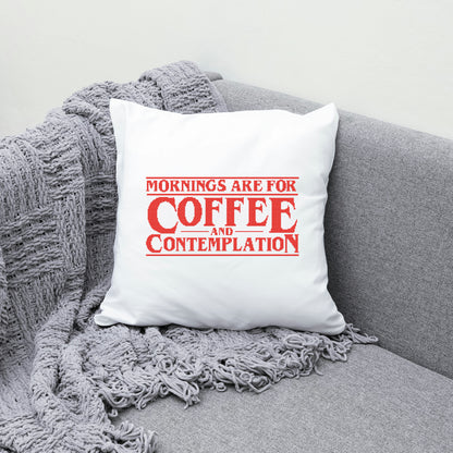 White pillow with red text on a gray couch