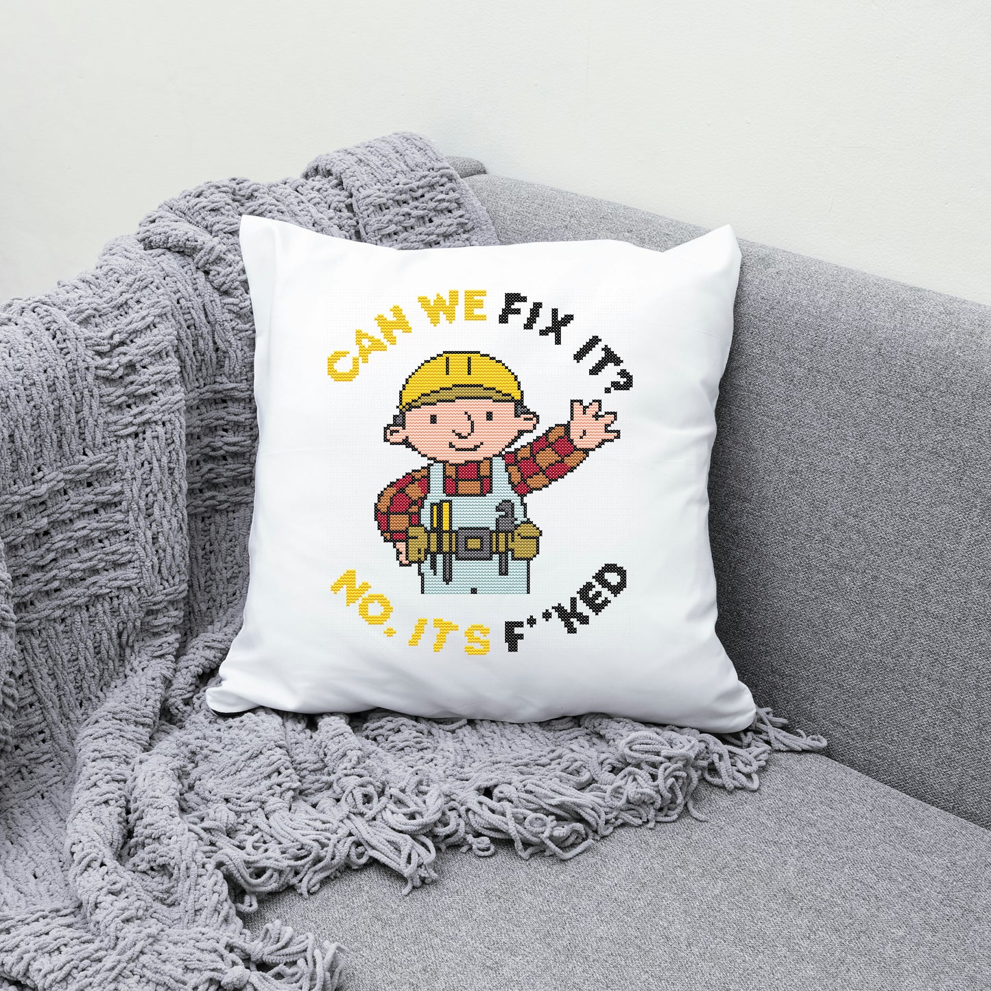 White pillow with cartoon character and text on a gray couch