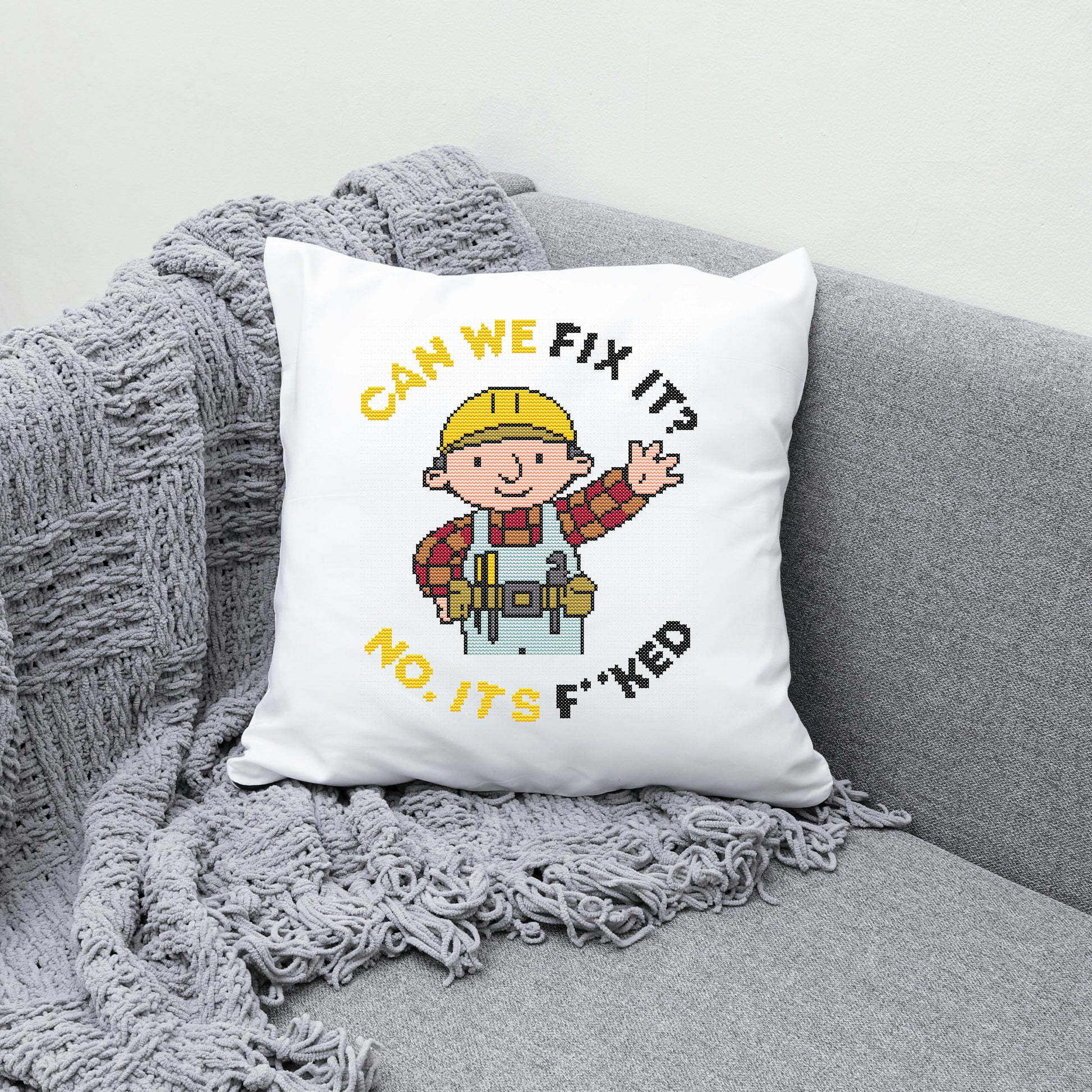 White pillow with cartoon character and text on a gray couch