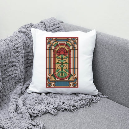 Decorative pillow with stained glass rose design on a gray couch.