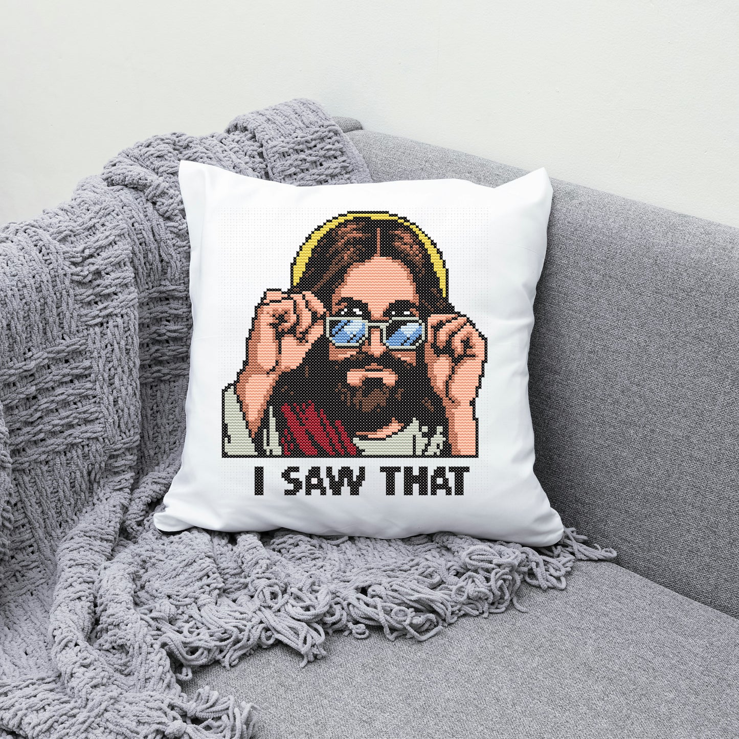 Pixelated pillow with a character holding sunglasses and 'I saw that' text on a gray couch.