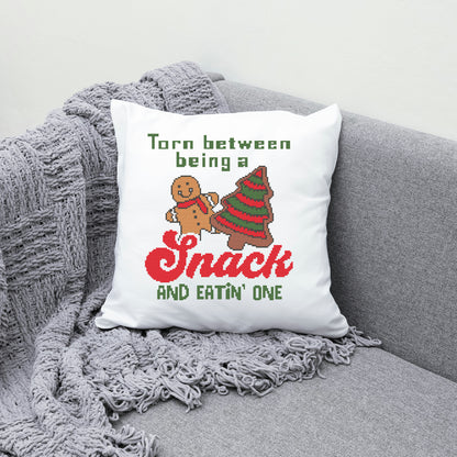 Decorative pillow with Christmas-themed text and graphics on a gray couch.