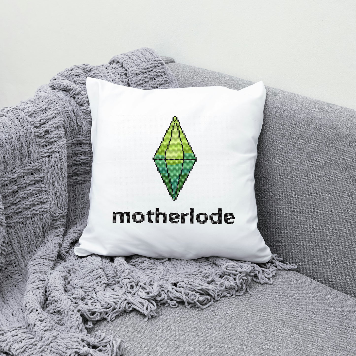 White pillow with 'motherlode' and logo on the grey couch