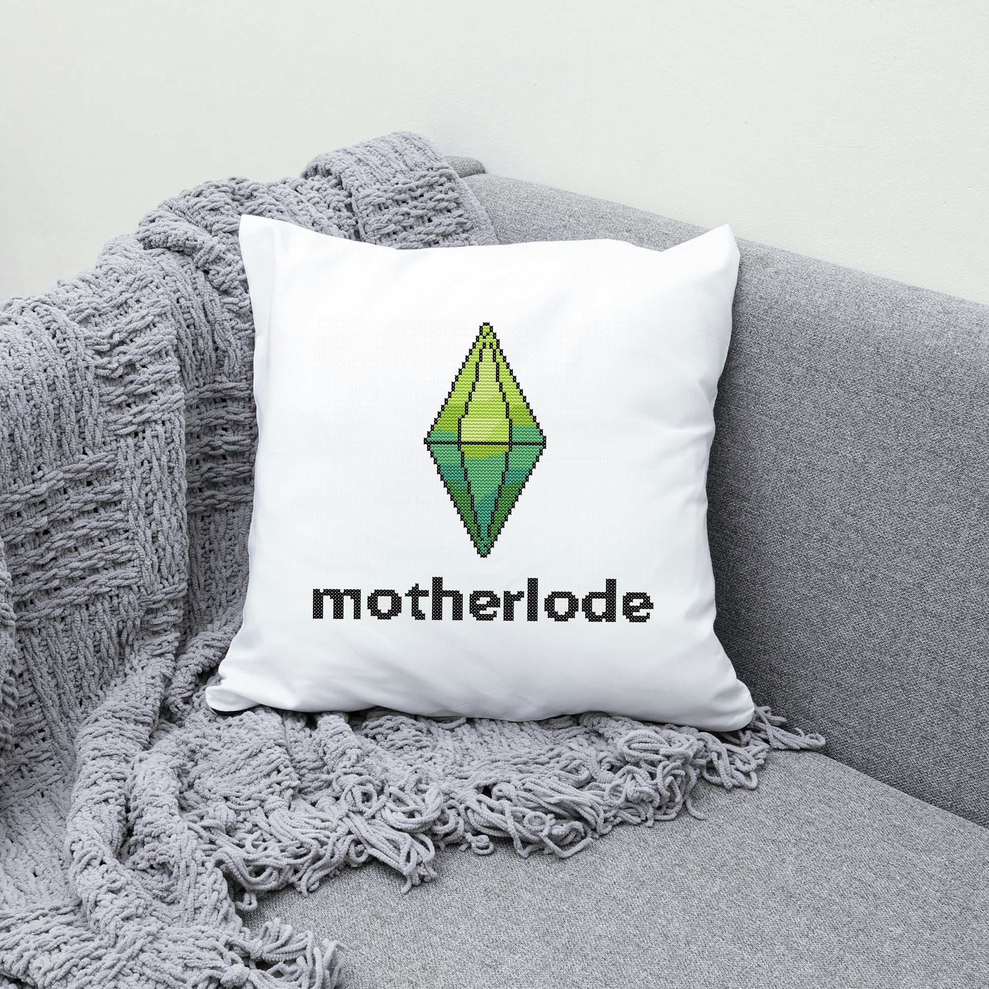 White pillow with 'motherlode' and logo on the grey couch