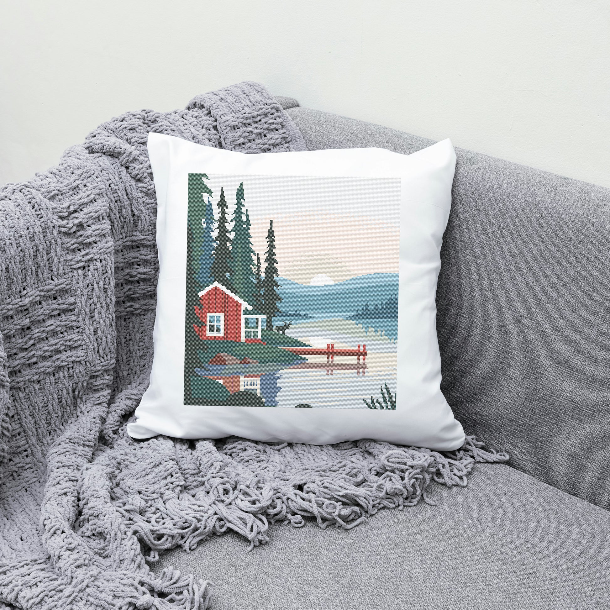Decorative pillow with a cabin design on a gray couch