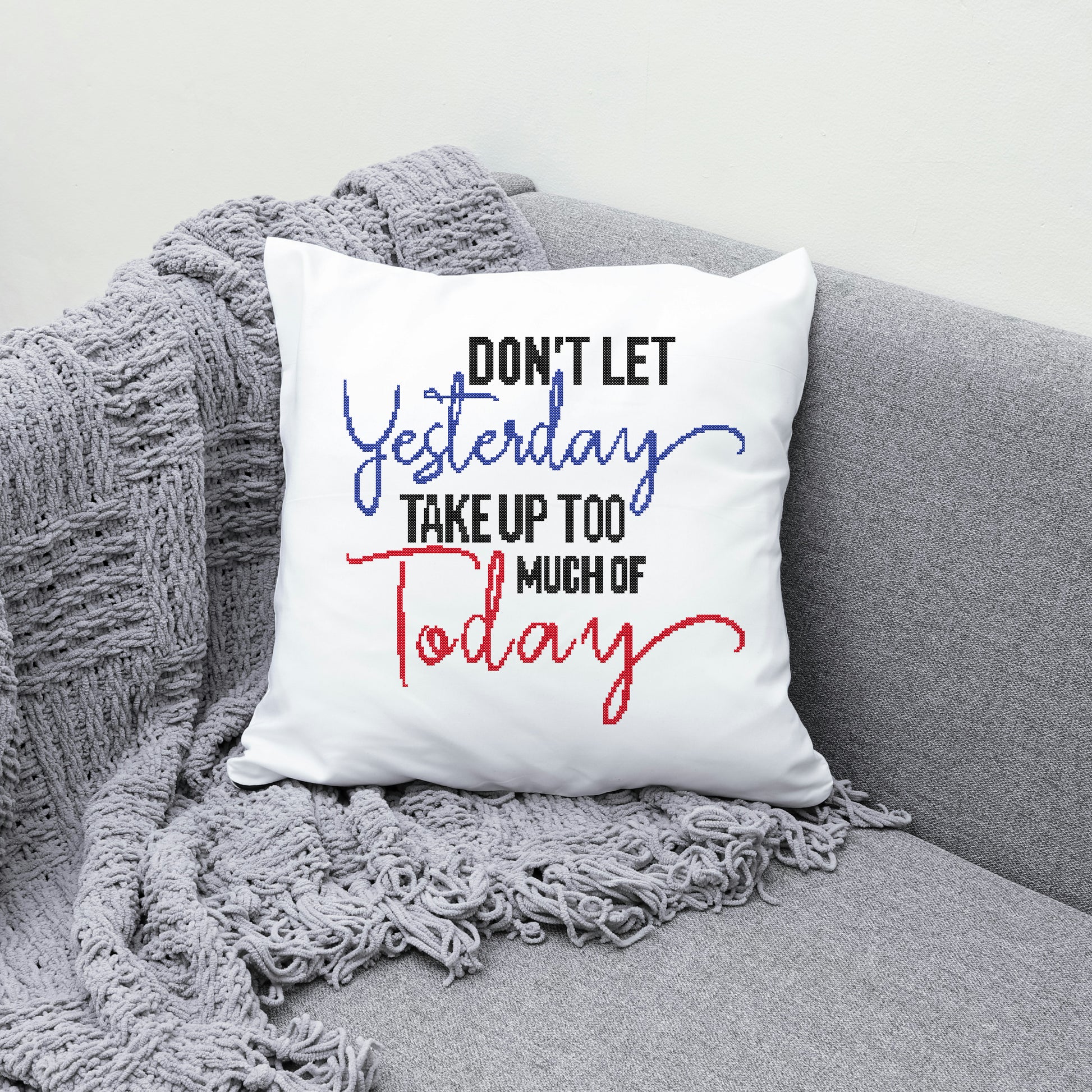 White pillow with motivational quote on a gray couch