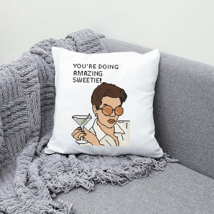 Pillow with a character holding a martini and text 'You're doing amazing, sweetie!' on a gray couch.