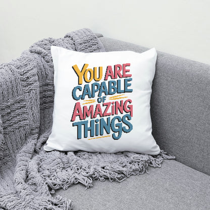 White pillow with motivational quote on a gray couch