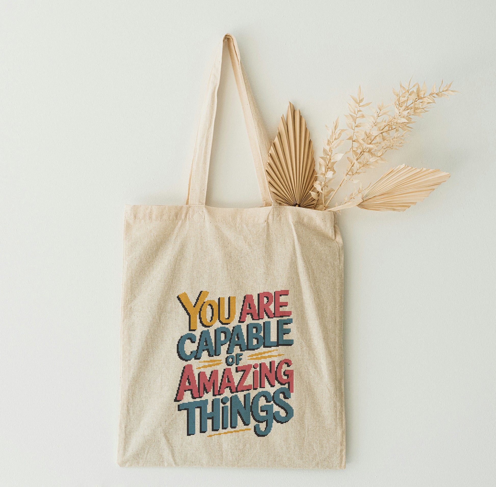 Tote bag with motivational quote on a white wall