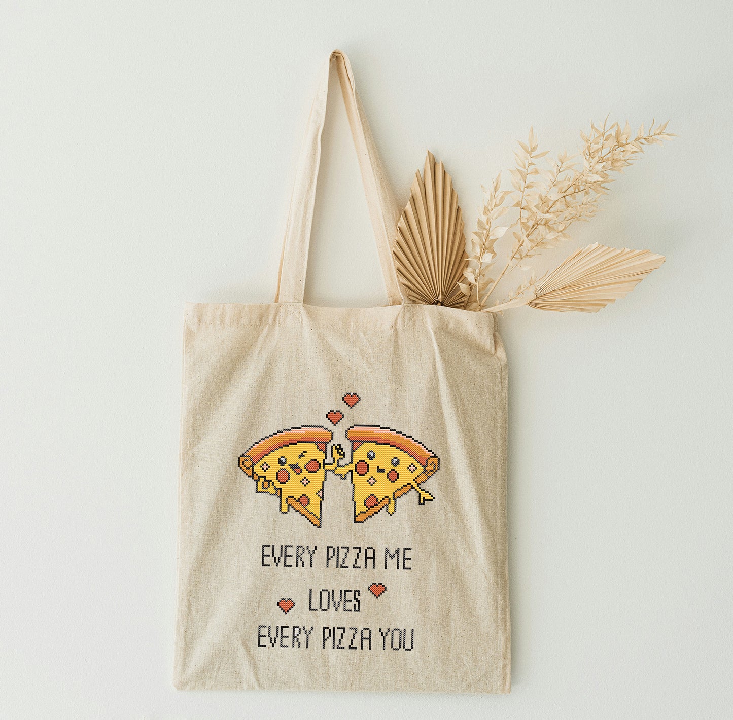 Beige tote bag with pizza graphic and text on a white background