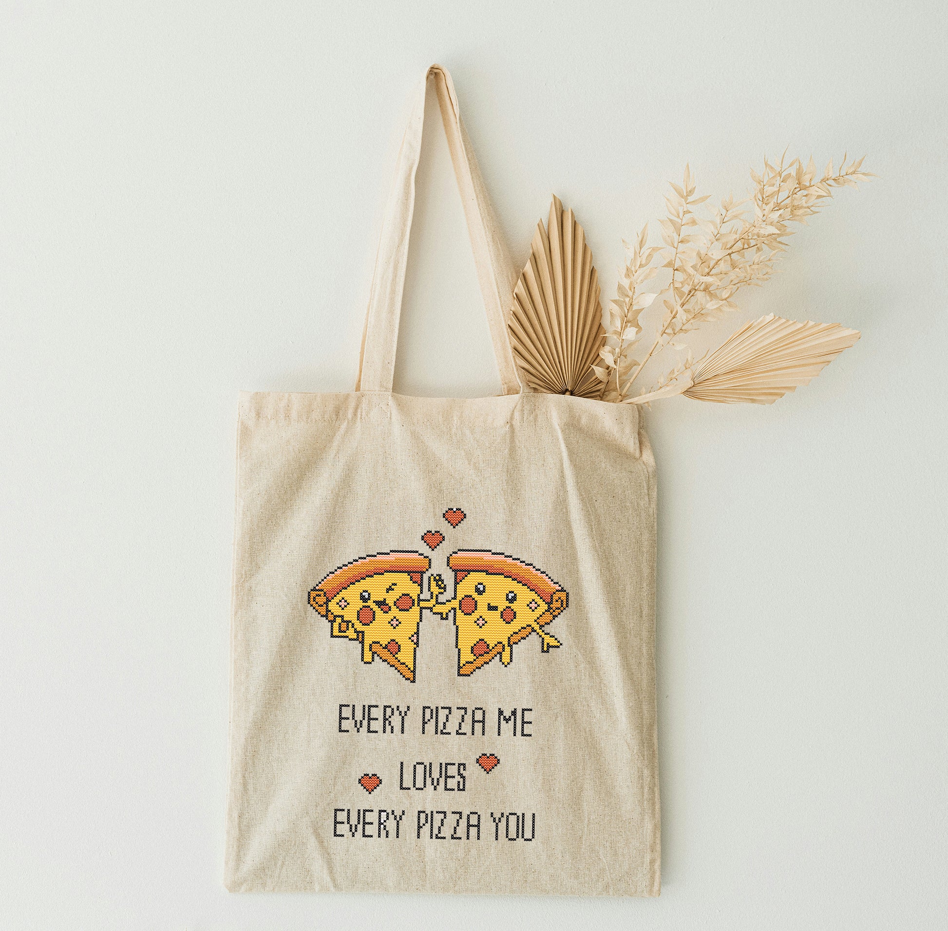 Beige tote bag with pizza graphic and text on a white background