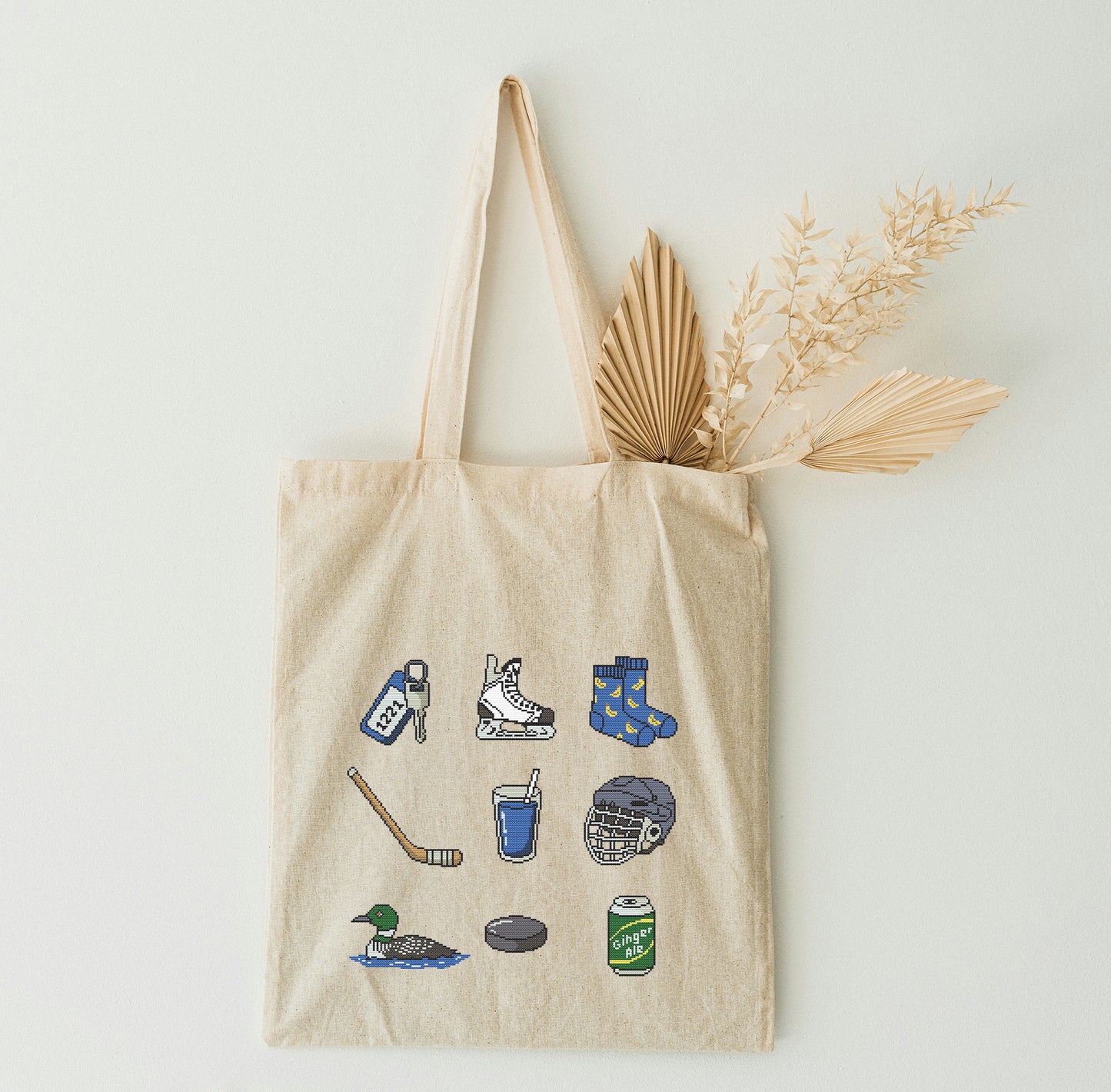 Beige tote bag on the white wall.
