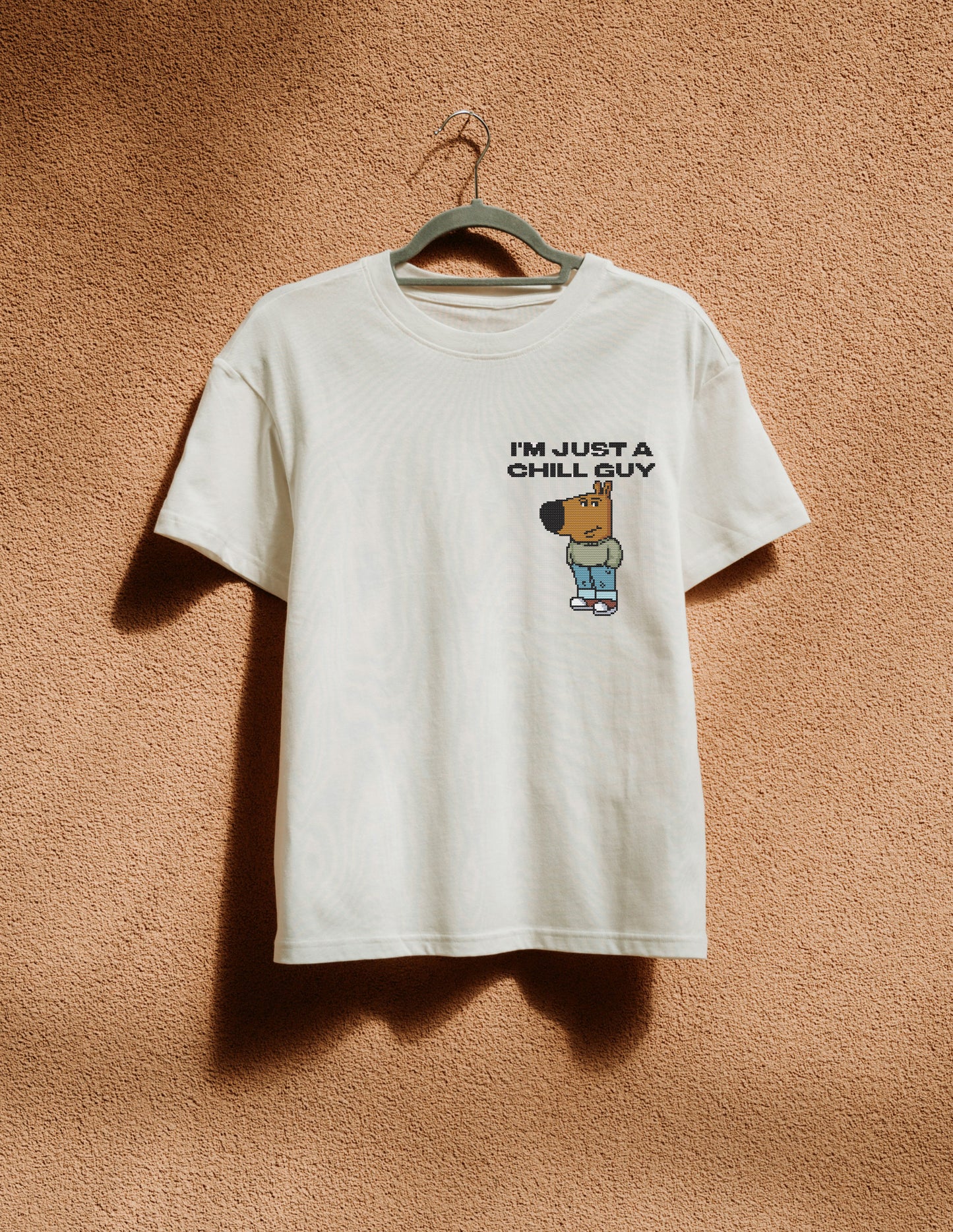 White t-shirt with logo print hanging on the beige wall