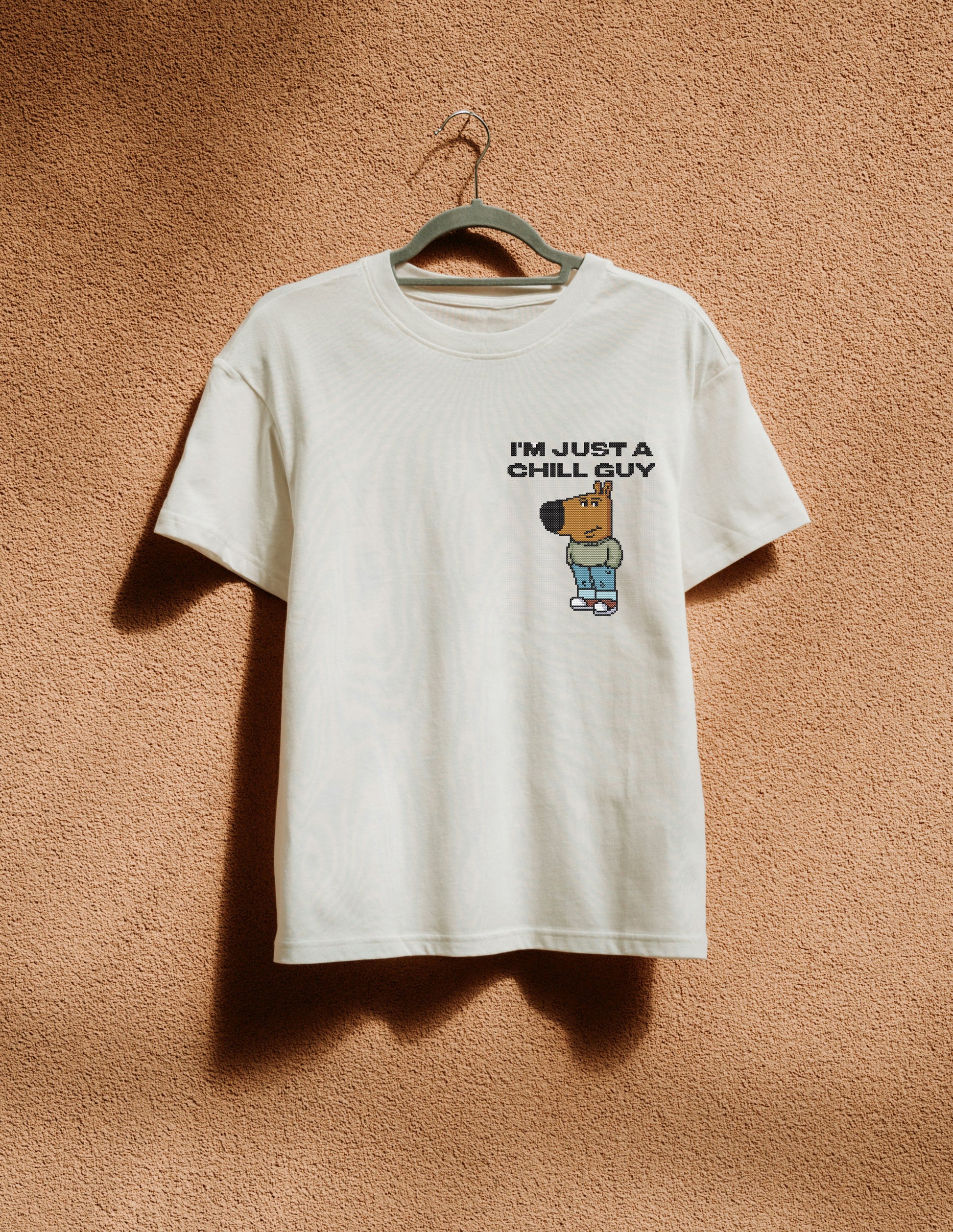 White t-shirt with logo print hanging on the beige wall
