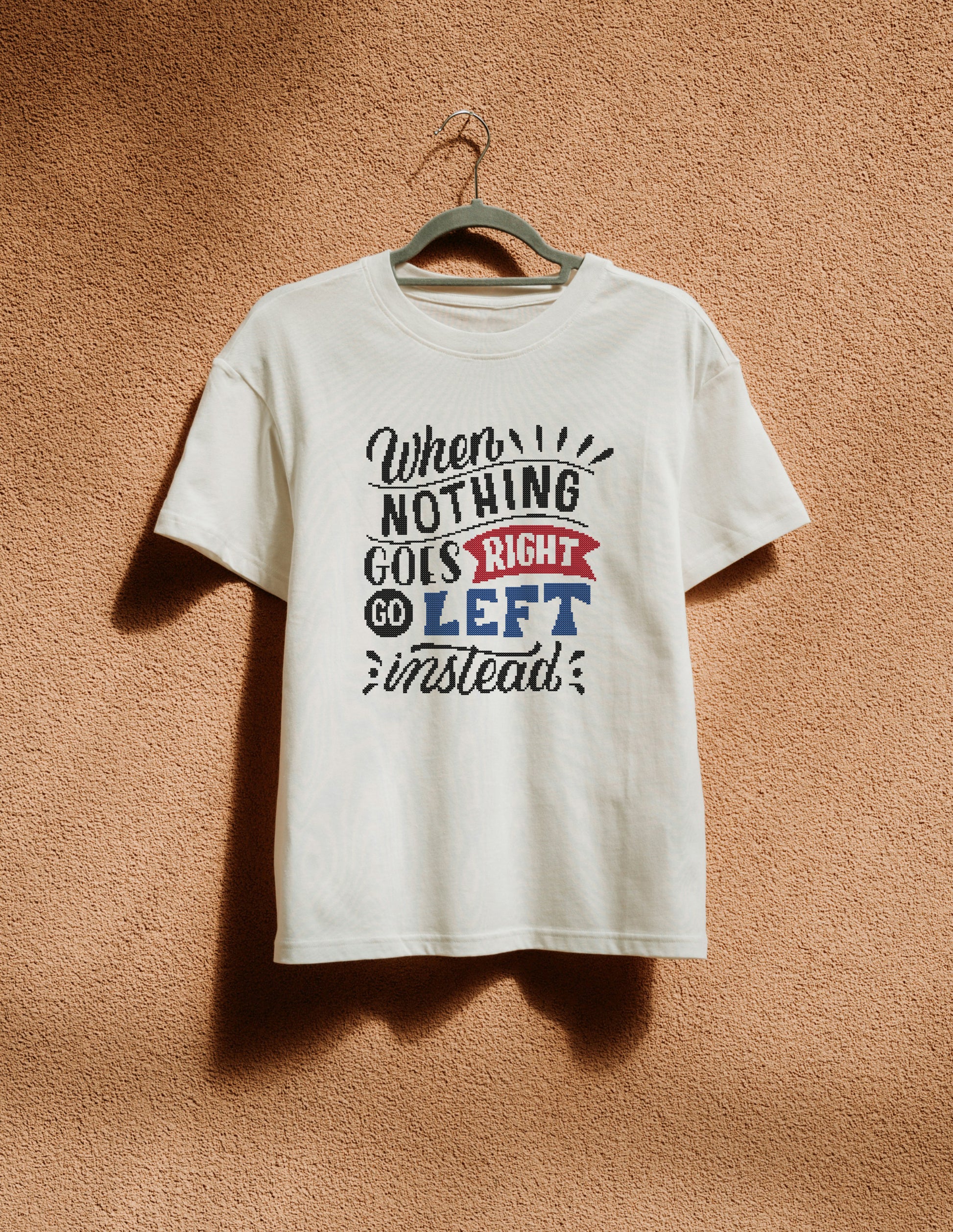 White t-shirt with humorous text design on a beige wall