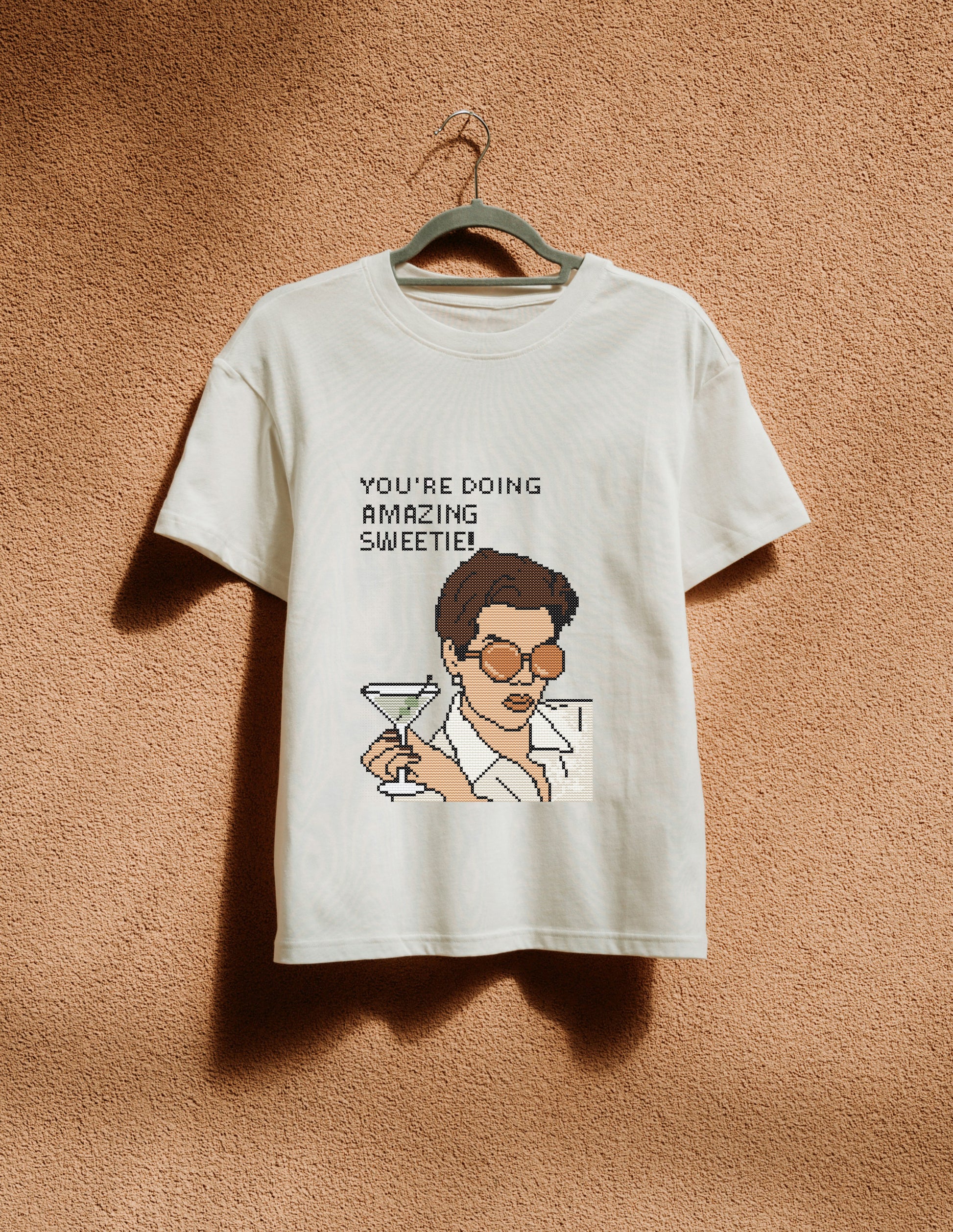 White t-shirt with graphic design and text on a beige background