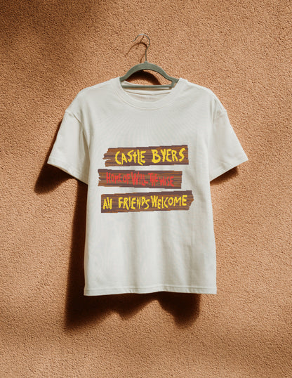 White t-shirt with text design on a hanger against a textured brown wall