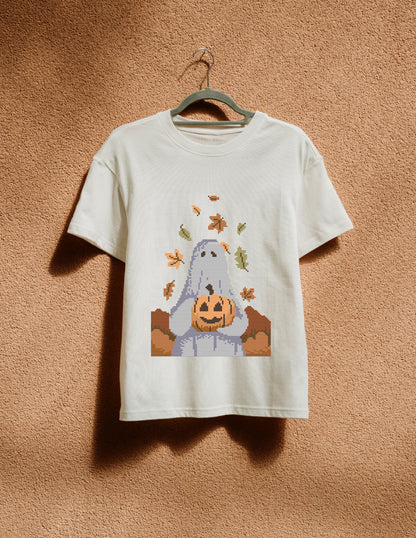 White t-shirt with a ghost holding a pumpkin design on a beige background