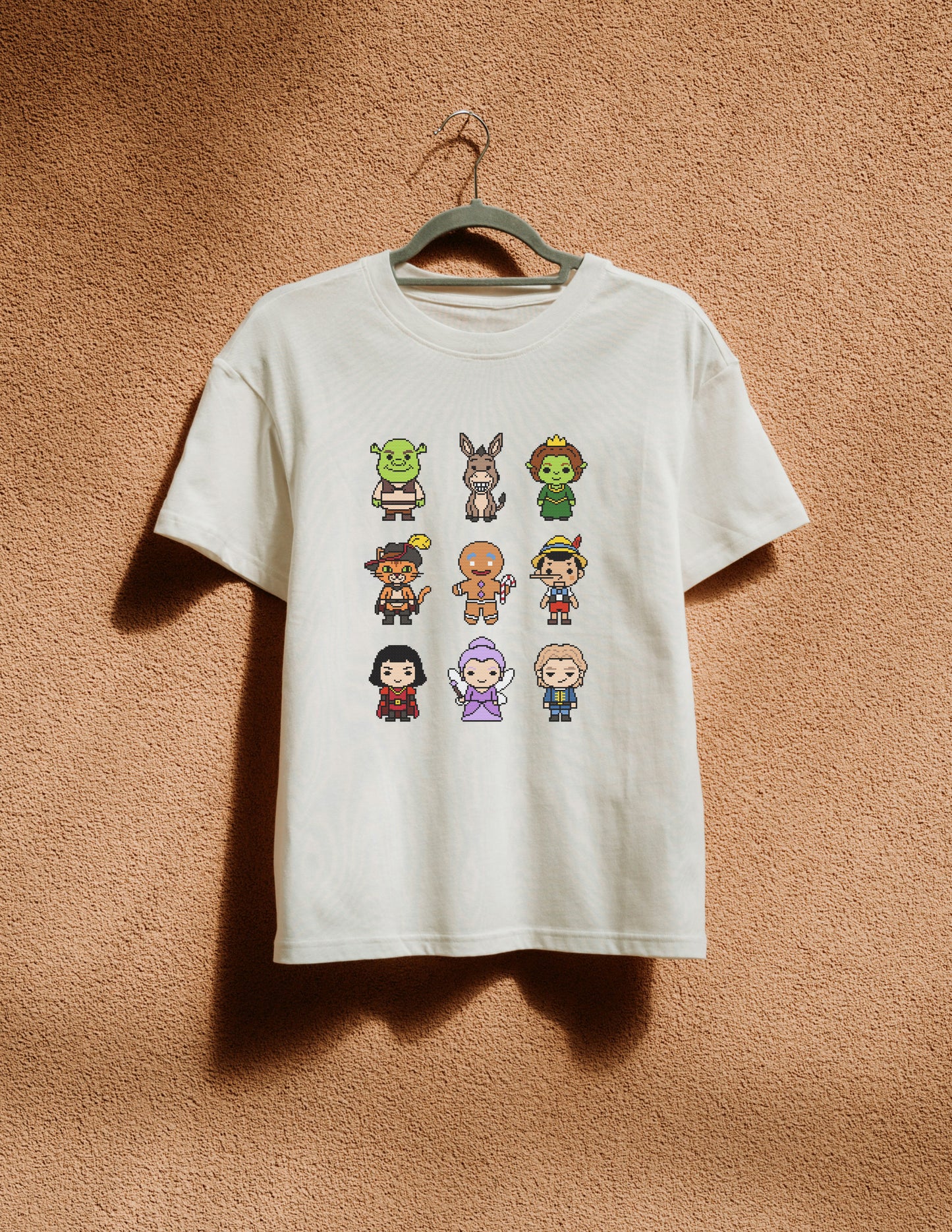 White t-shirt with pixel art character design on a beige background