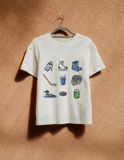 White t-shirt with graphic designs on a hanger against a brown textured wall