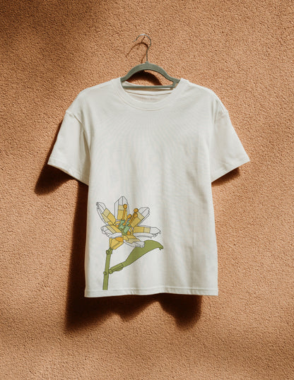 White t-shirt with a colorful flower design on a hanger against a brown textured wall.