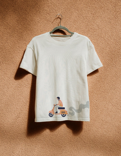 White t-shirt with graphic design on a hanger against a beige wall