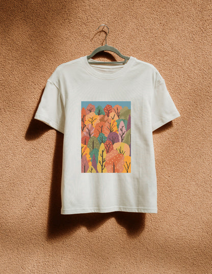 White t-shirt with a colorful forest design on a beige wall