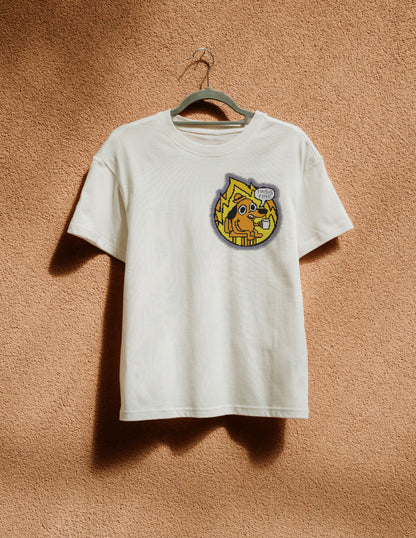 White t-shirt with a colorful graphic on a hanger against a brown textured wall