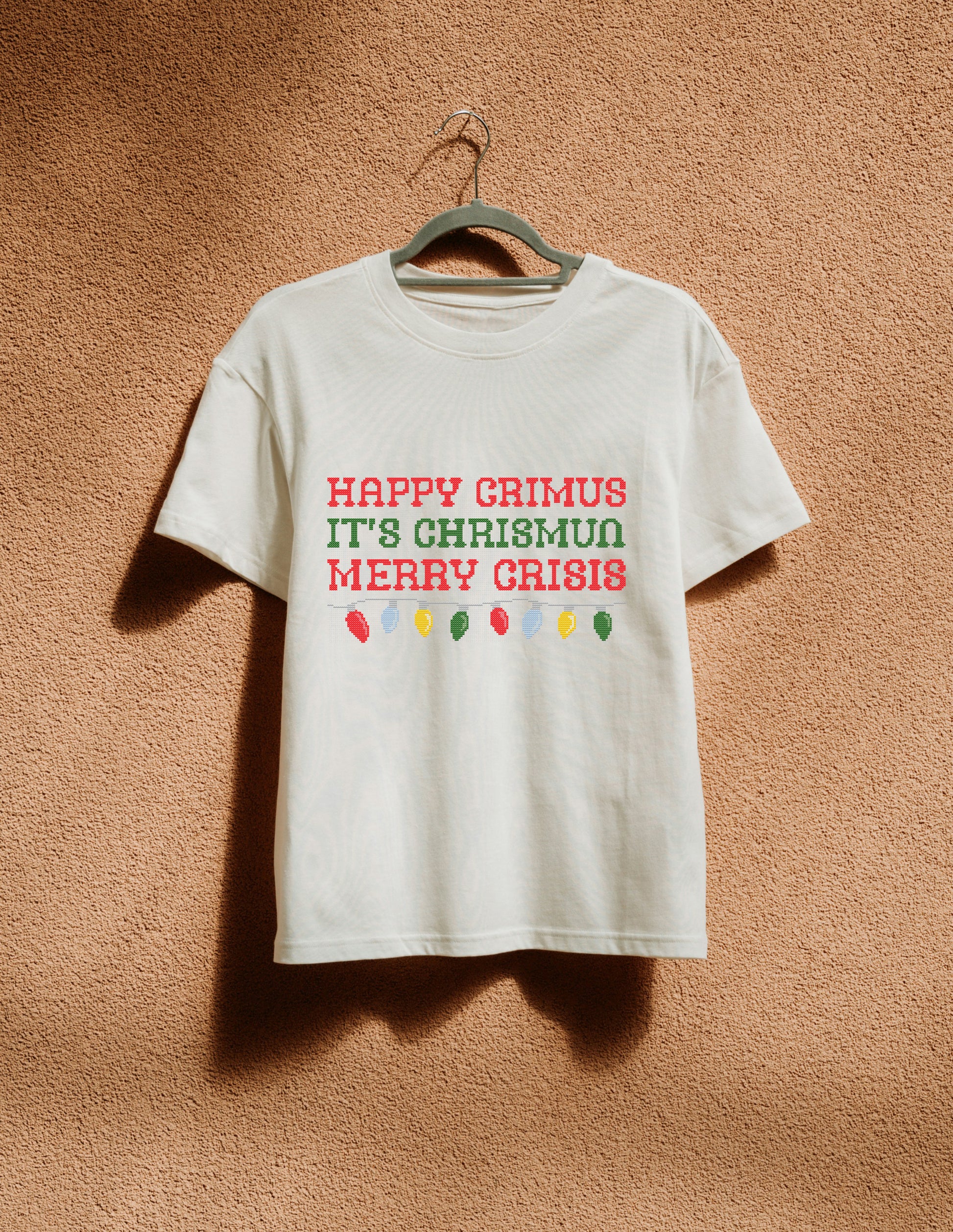White t-shirt with humorous Christmas text design on a textured brown background