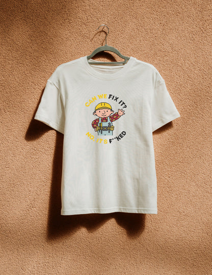 White t-shirt with cartoon character and text on a hanger against a brown textured wall