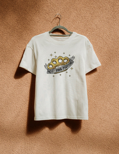 White t-shirt with logo print hanging on the beige wall