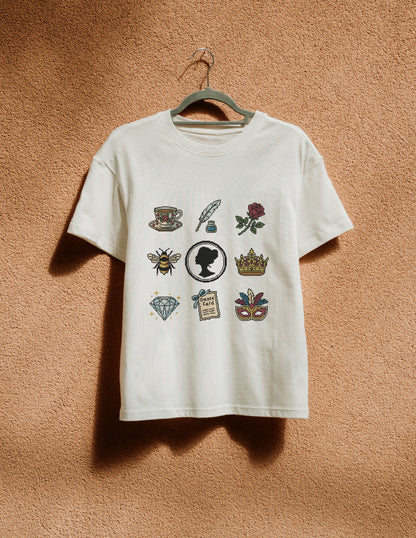 White t-shirt with various graphics on a hanger against a textured brown wall