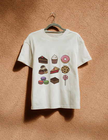 White t-shirt with dessert graphics on a hanger against a textured brown wall