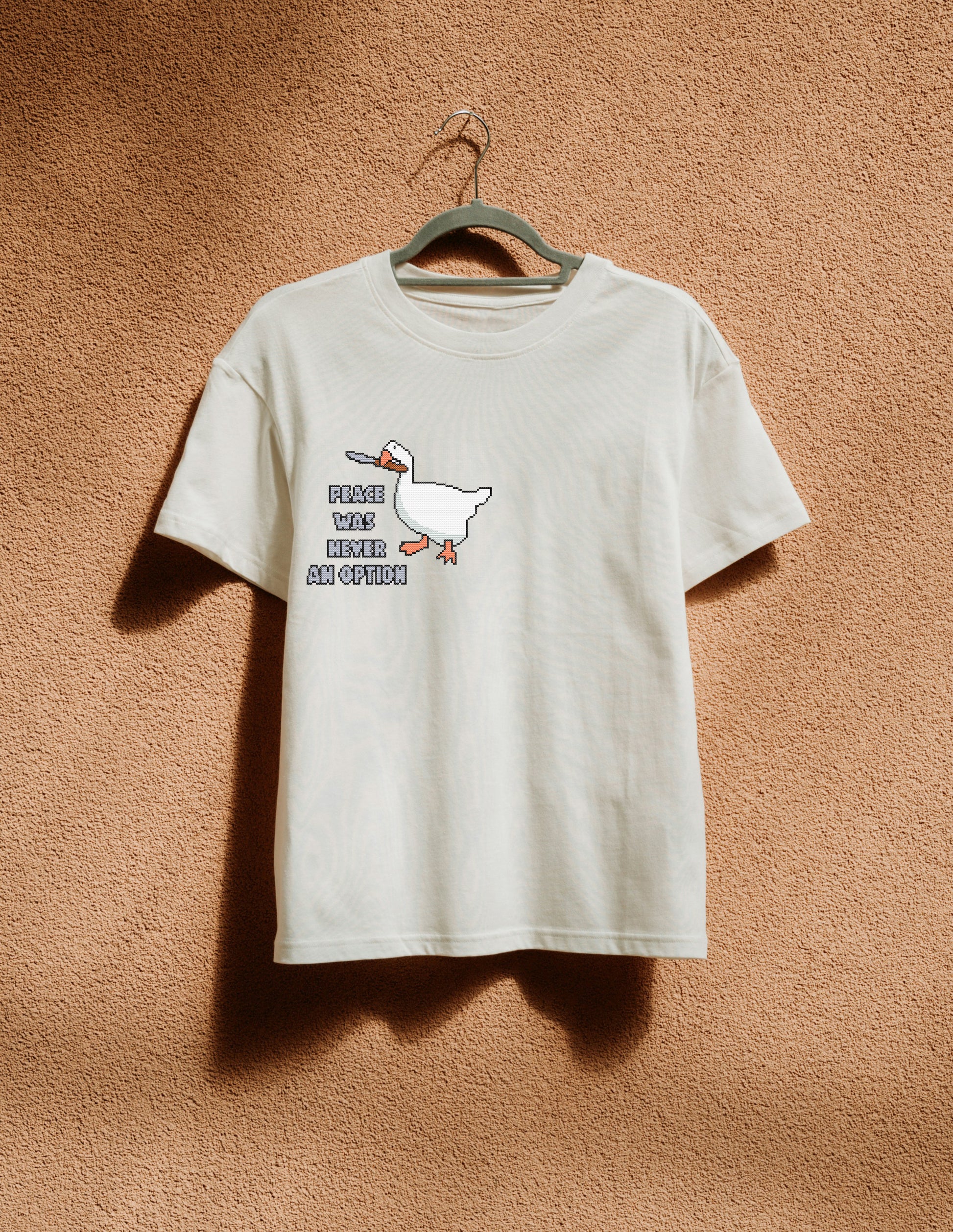 White t-shirt with a graphic design of a duck and text on a beige background
