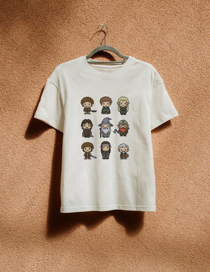 White t-shirt with pixelated character designs hanging on a hanger against a brown textured wall.