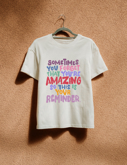 White t-shirt with colorful text on a hanger against a brown textured wall