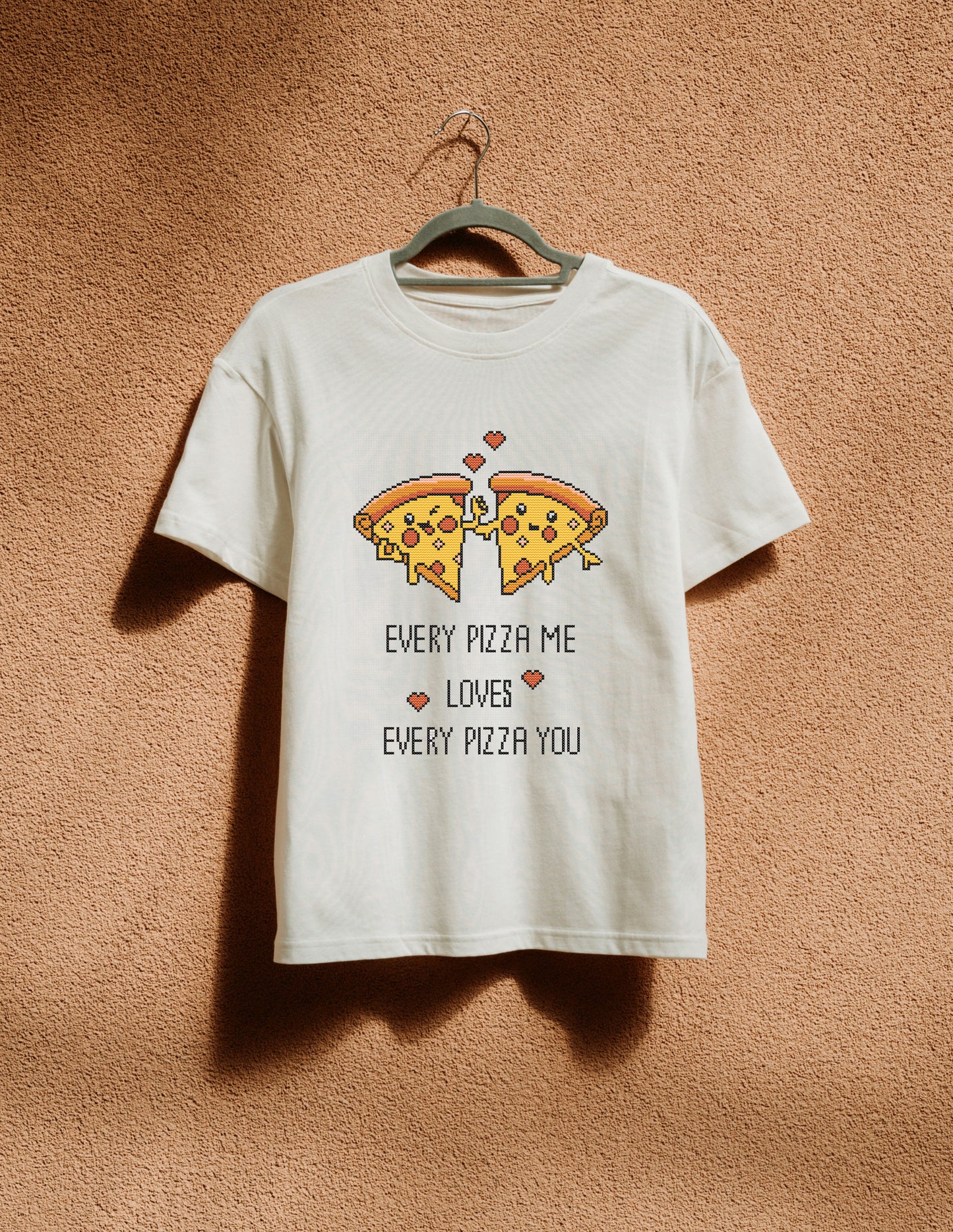 White t-shirt with pizza graphic and text on a beige background