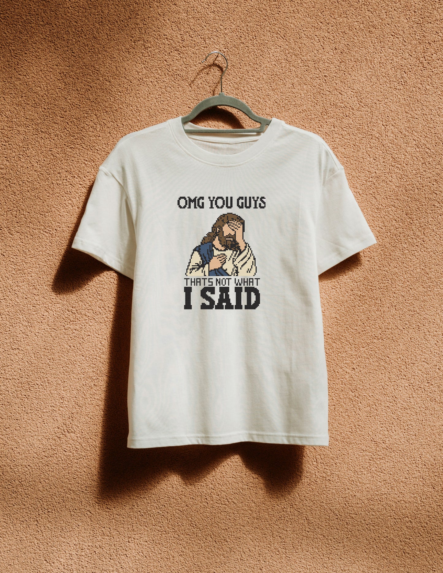 White t-shirt with graphic design and text on a beige background